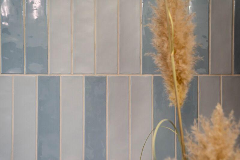 Schmale Riemchen in Blau und Weiß mit glänzender Glasur, senkrecht verlegt