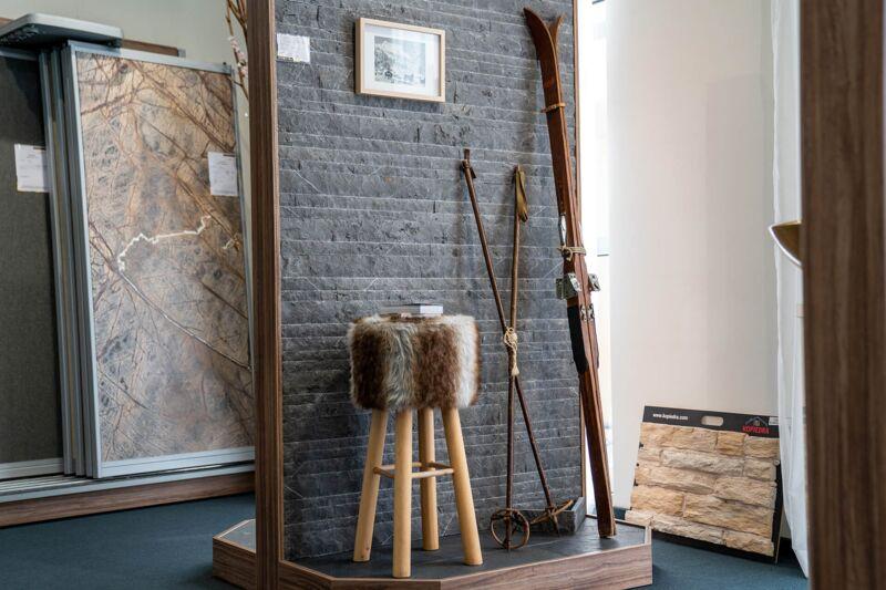 Koje mit Wand aus Schieferriemchen, Fellhocker und alten Skiern in der Ausstellung Bonn